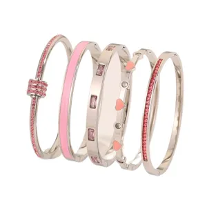 Set aus 5 silbernen Edelstahl Armreifen mit rosa Kristallen, Emaillierung und Herzmotiven.