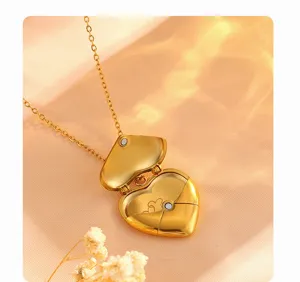 Detailed view of the 18k gold heart envelope locket necklace, open design with magnetic clasp.
