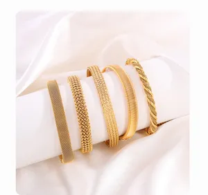 Detail view of five gold titanium steel bracelets featuring intricate braided mesh textures.