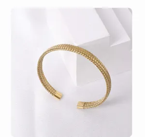 Gold stainless steel woven mesh open cuff bangle detail, elegant minimalist jewelry design.