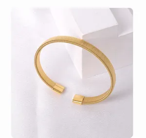 Gold titanium steel open spring bracelet detail shot, elegant and minimalist wrist item.