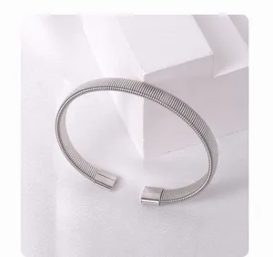 Titanium steel spring cuff bracelet, elegant open metal bangle for modern women.
