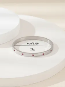 Dettaglio del bracciale in acciaio inossidabile con pietre rosa intarsiate e misurazione.