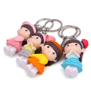 Gedetailleerd overzicht van kleine meisjes pop sleutelhanger, kleurrijke hanger.