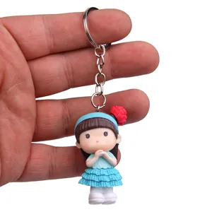 Detailopname van een schattig meisje figuur sleutelhanger in blauwe jurk voor tassen.