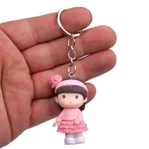 Leuke cartoon meisjespop sleutelhanger met roze jurk en metalen ring voor handtassen.