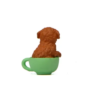 Leuke bruine poedel hond figuur in groene thee kop miniatuur hars tuindecoratie.