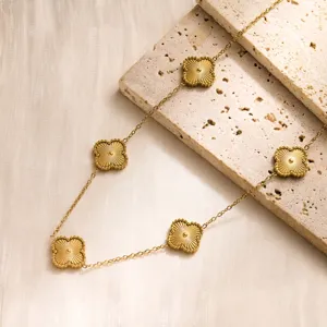 Detail shot of exquisite stainless steel gold clover necklace with sunburst texture.