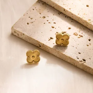 Exquisite gold stainless steel clover stud earrings with faceted texture, elegant luxury style.