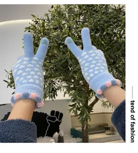 Winter warm touch screen knit gloves for women with cute heart pattern and plush pom cuffs.