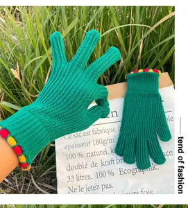 Detailed shot of winter warm green knit gloves with colorful cuffs for women cycling.