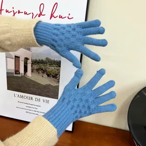 Detailed view of blue knitted winter gloves for women, featuring textured pattern and warm design.