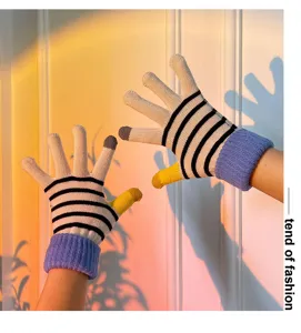 Close-up view of knit touchscreen gloves featuring black white stripes and purple cuffs.