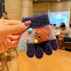 Close-up view of toddler knitted gloves, showing cute cartoon patch and cozy winter fabric.