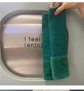 Detailed view of dark green knitted arm warmers with plush cuffs for autumn winter cozy style.