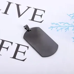 Close up of black stainless steel dog tag pendant, minimalist design, smooth texture detail.
