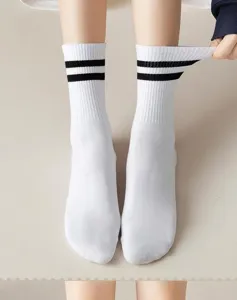 Close-up of classic white cotton mid-tube socks featuring black double stripes detail.