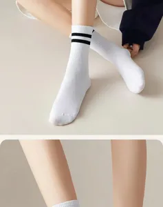 White casual athletic crew socks with black stripes, classic college style unisex pair.