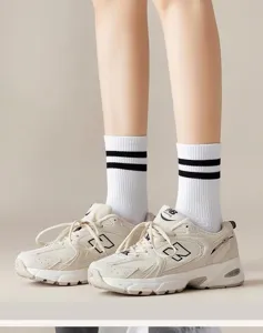 Detail view of stylish black and white striped cotton mid-tube casual sports socks.