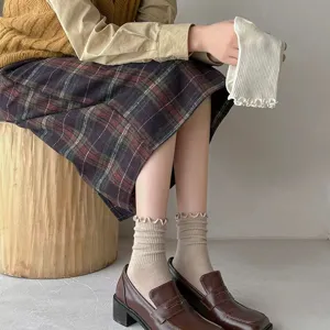 Women's Japanese style ruffle edge mid-calf stackable socks worn with loafers and skirt.