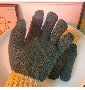 Primo piano di guanti invernali caldi in maglia touch screen con polsini a coste gialli.