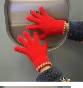Red fuzzy knit gloves detail showing plush texture and colorful dot cuffs for winter warmth.