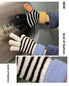 Close-up detail of winter warm touch screen knit gloves with black and white stripes.