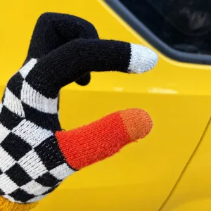 Close-up detail of winter knit touchscreen gloves featuring a stylish checkerboard pattern.