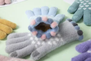 Dettaglio di simpatici guanti invernali in maglia da donna, guanti caldi touch screen multicolore.