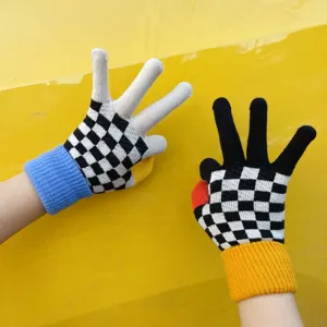 Detail view of stylish black and white checkerboard knit gloves with colorful cuffs.