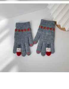 Close-up detail of grey winter knit touch-screen gloves with cute heart and XX pattern fingers.