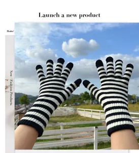 Black and white striped knit winter gloves featuring a stylish touch screen compatible design.