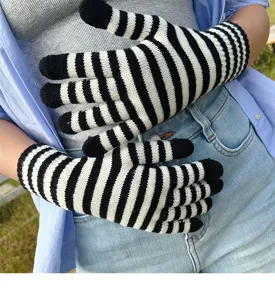 Black and white striped knit gloves close-up shot, soft warm winter accessory detail.