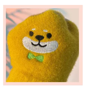 Cute yellow cartoon bear embroidered winter glove detail close-up, thick fleece warm design.