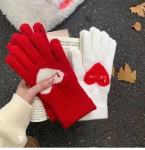 Gedetailleerd overzicht van schattige gebreide winterhandschoenen met een lief rood-wit hartjespatroon.