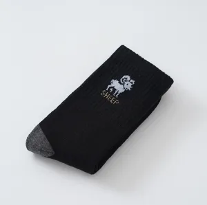 Detailed shot of thick winter crew socks with pixel sheep embroidery and cozy fleece lining.