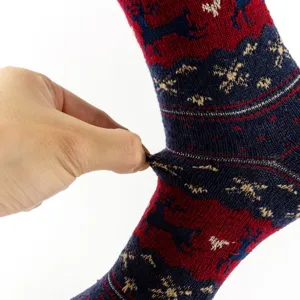 Close-up of thick winter warm women socks with elk pattern and gold thread details.