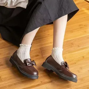 Detailed view of sweet Japanese style white frilly socks paired with brown bow loafers for women.