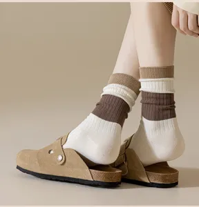 Women's mid-tube socks paired with suede clogs, stylish striped knit fashion hosiery for autumn.