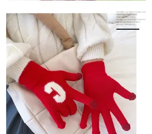 Nahaufnahme roter Strick-Touchscreen-Handschuhe mit Buchstaben, warme Winterbekleidung.
