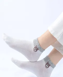 Gros plan de chaussettes invisibles en maille respirante avec broderie d'ours et bordures gris.