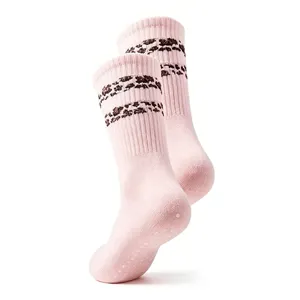 Close-up detail of pink yoga pilates socks featuring brown leopard stripes and anti-slip grip sole.