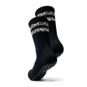 Close-up detail of black grip yoga socks, anti-slip pilates floor socks with leopard.