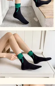 Black cotton crew socks for women featuring a cute green four-leaf clover design, soft and breathable.