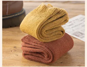 Close-up detail view of thick thermal winter cotton socks stacked neatly on wooden table.