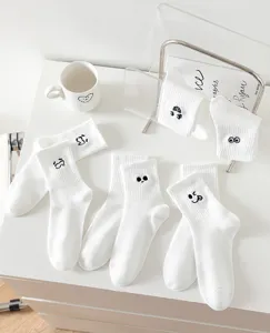 White women's mid-tube cotton socks featuring cute funny facial expression embroidery details.