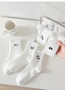 White mid-tube cotton socks featuring cute funny facial expression embroidery details.