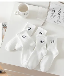 White crew socks for women featuring cute funny expression embroidery, casual cotton socks.