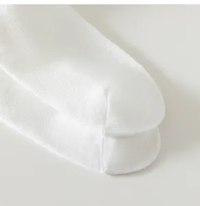 Close-up detail of white women's socks showing soft cotton knit texture, breathable and fine.