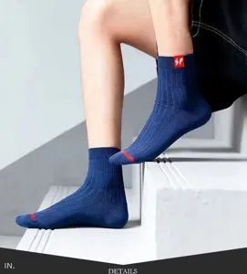 Men's ribbed crew socks detail shot, blue cotton knit socks with red toe and cuff tag.